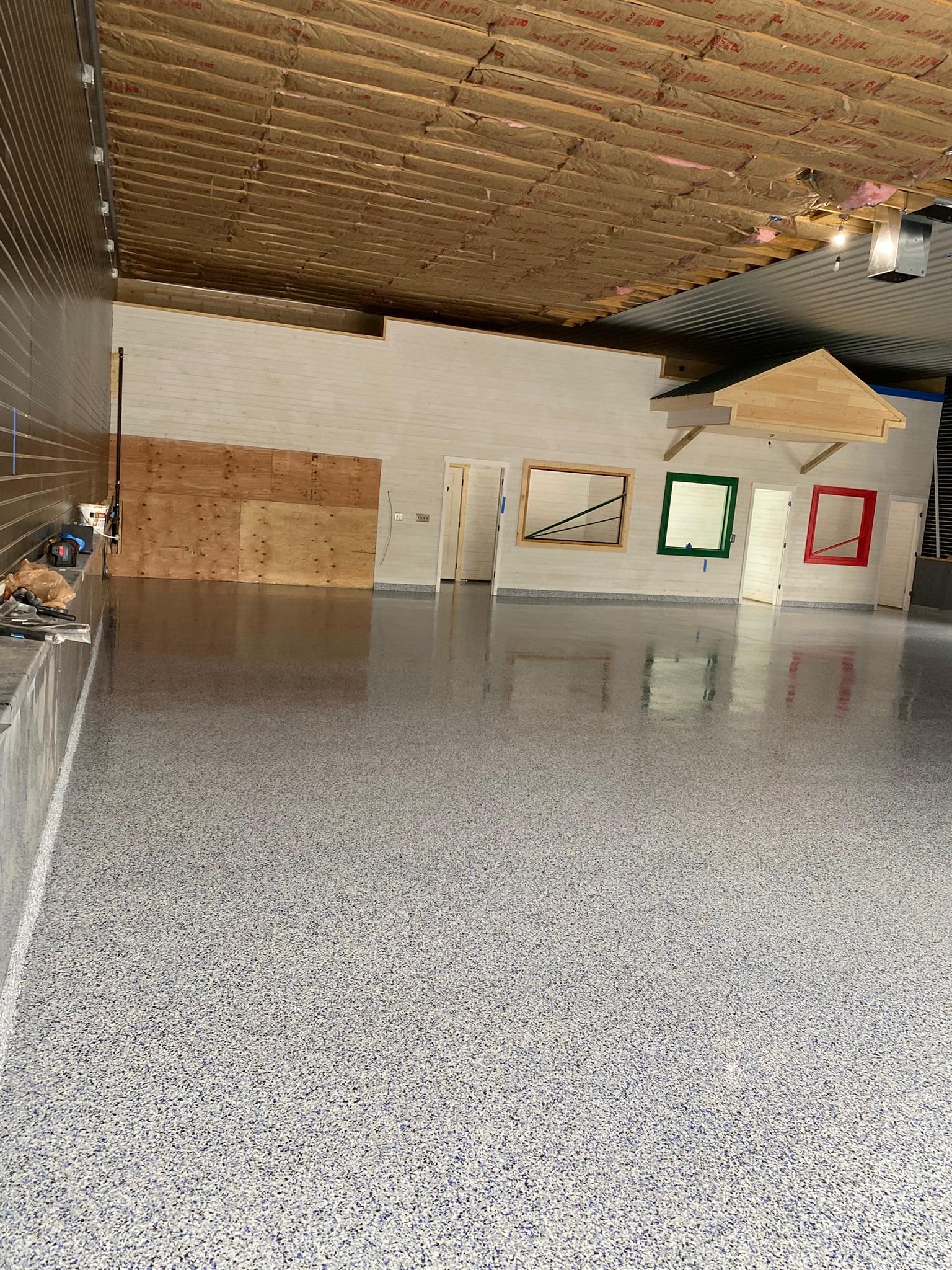 Finished grey flake epoxy floor with high-gloss topcoat in a commercial indoor space