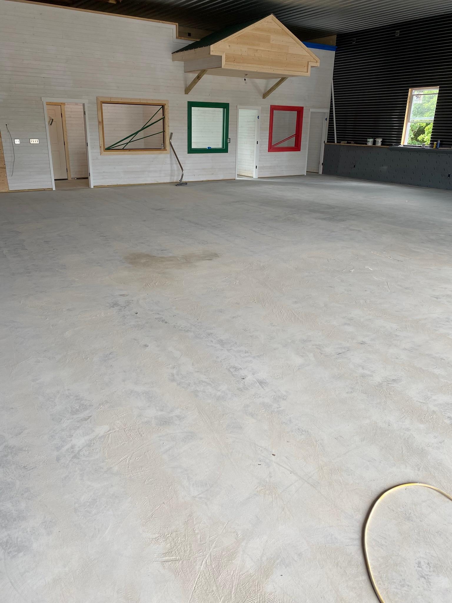 Bare concrete floor before epoxy coating in a commercial indoor space