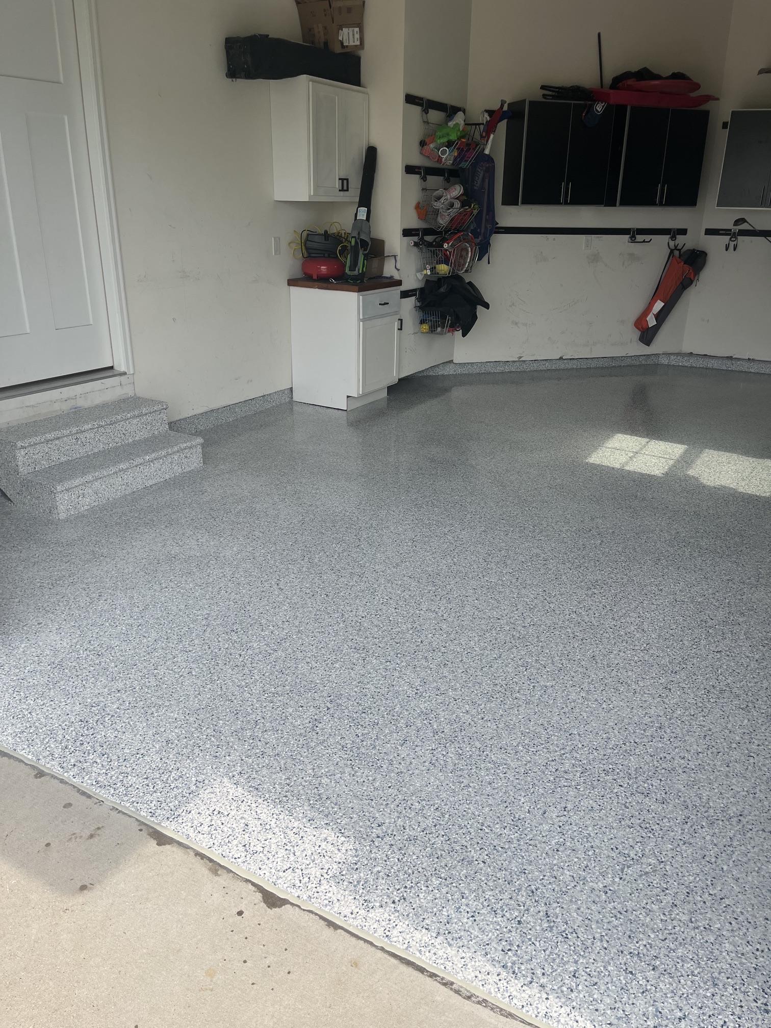 Side view of glossy flake garage floor with matching coated stairs and stem wall